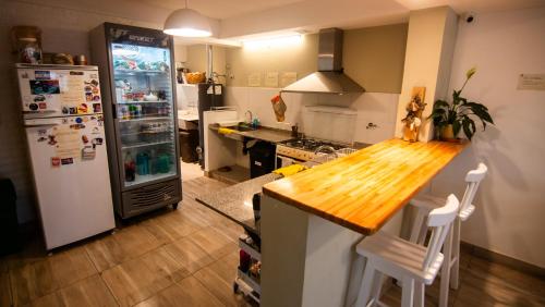 a kitchen with a refrigerator and a wooden counter top at Casa Amonite Hostel Boutique in Puerto Madryn