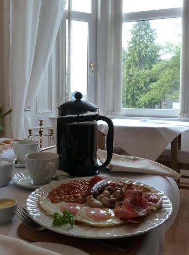 a plate of food on a table with a tea pot at Failte Bed & Breakfast in Oban