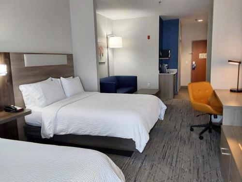 a hotel room with two beds and a desk at Holiday Inn Express Hotel & Suites Antigo by IHG in Antigo