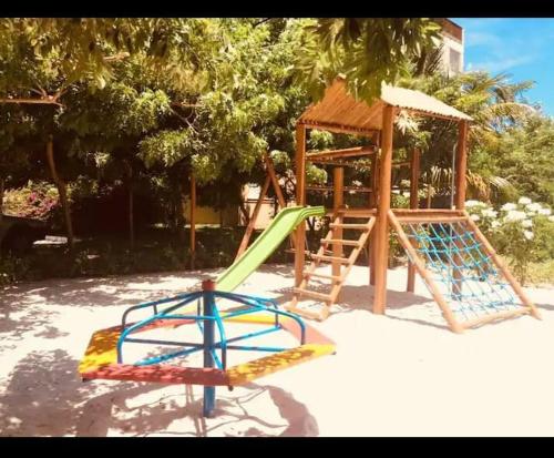 a playground with a slide and a swing set at Apartamento confortável e arejado in Monte Gordo