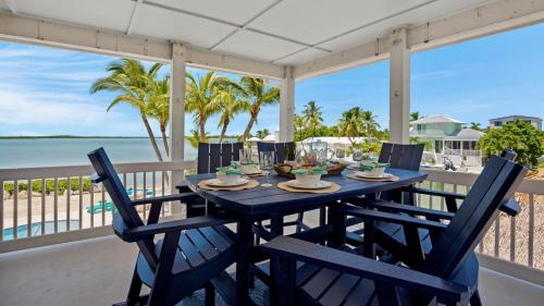 a blue table with chairs on a balcony with the beach at Infinite Horizons by Last Key Realty in Stock Island