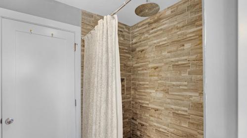 a shower in a bathroom with a wooden wall at Infinite Horizons by Last Key Realty in Stock Island
