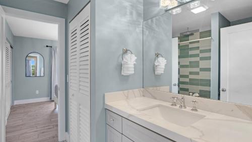 a white bathroom with a sink and a mirror at Infinite Horizons by Last Key Realty in Stock Island