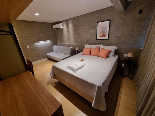 a small bedroom with a bed and a chair at Flat Asa Norte CLN 311 by CentoEdez in Brasilia