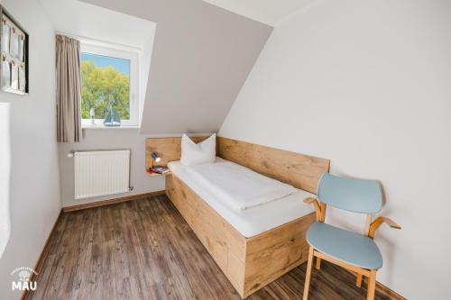a small room with a bed and a chair at Ferienbauernhof Mau in Fehmarn