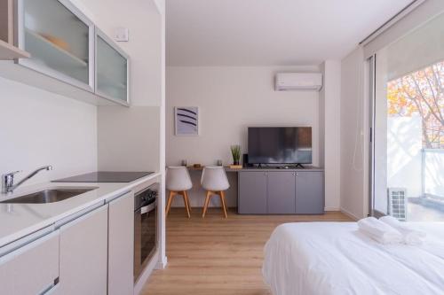 a white kitchen with a bed and a sink at Recoleta, cómodo, cerca de todo, WiFi, Balcón in Buenos Aires