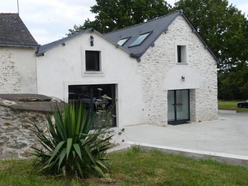 a white brick house with a black roof at Jolie longère près Canal Nantes-Brest ' Pétanque in Guenrouet