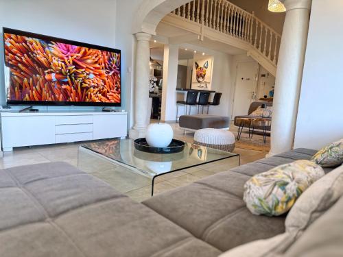 un salon avec un canapé et une télévision à écran plat dans l'établissement Villa Prestige 5 étoiles, Piscine, Jacuzzi & Vue - Climatisation, à Marseille