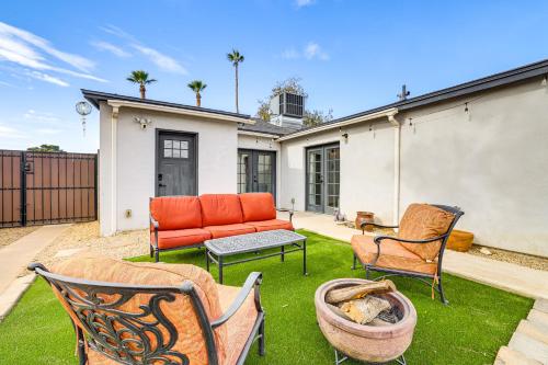a backyard with a couch and chairs on the grass at 1 Mi to Grand Ave Modern Home with Spacious Yard! in Phoenix
