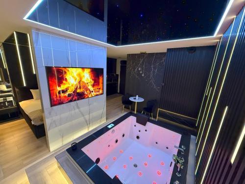 a living room with a hot tub in front of a fireplace at Wiślane Tarasy 2 VIP Apartamenty JACUZZI in Krakow