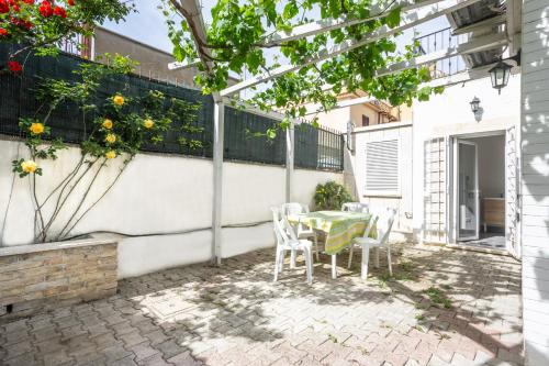 a patio with a table and chairs and flowers at La Pergola in Fiore in Passoscuro