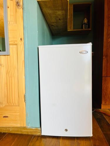 a white refrigerator in a room with a blue wall at Soka Oceanview Loft Near Beach 15min Walk in Bastimentos