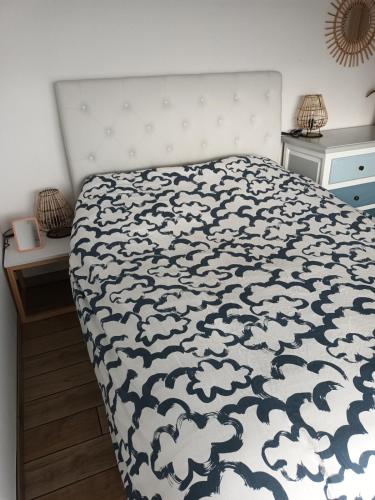 une chambre avec un lit avec une couette noire et blanche dans l'établissement Maison face à l'océan classé 3 étoiles, à Montalivet-les-Bains