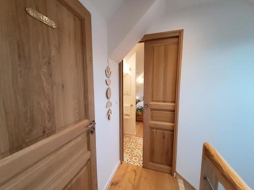a hallway with a wooden door and a stairway at Chambres Le Penty in Pleumeur-Bodou