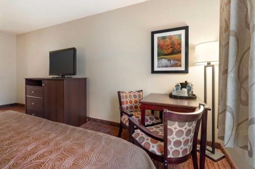 a hotel room with a bed and a desk and a tv at Best Western Plus Concord Inn in Minocqua
