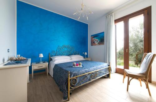 a blue bedroom with a bed with a blue wall at I Segreti di Antonina in Castelluzzo