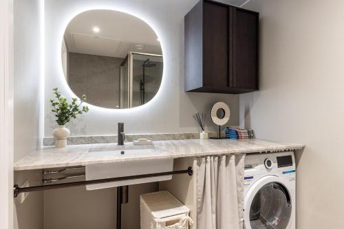 ein Badezimmer mit Waschbecken und Waschmaschine in der Unterkunft Nordic Gem in Stockholm