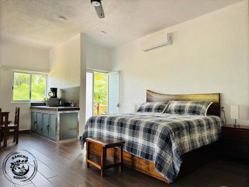 a bedroom with a bed with a checkered blanket at Suite Saasil Rancho Sodzil in Tizimín