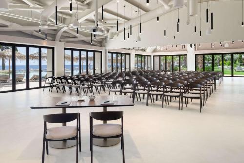 a large room with rows of tables and chairs at Isla Brown Corinthia Resort & Spa, Curio Collection by Hilton in Agioi Theodoroi