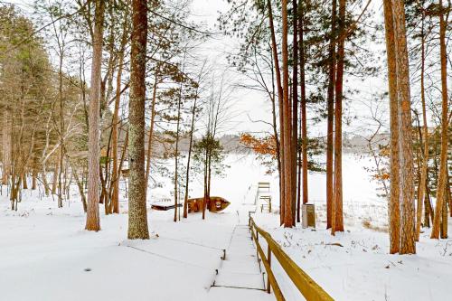 a snow covered path in a forest with trees at Hillis House in Arbor Vitae