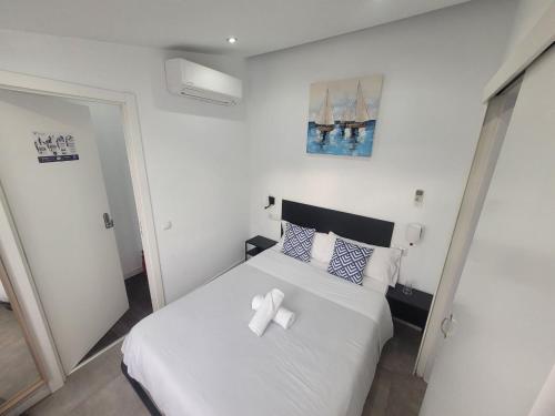 a bedroom with a white bed with a white bow on it at AYZ Frailes - Auto check-in property in Málaga