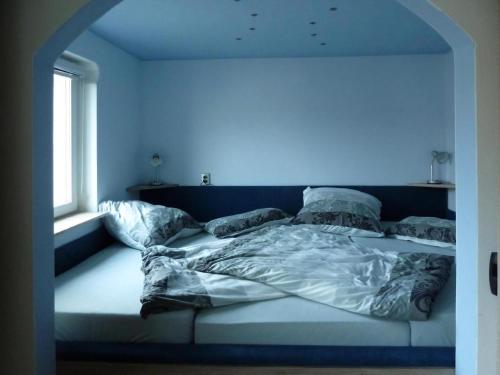 a bed in a room with a blue wall at Ferienwohnung Pügner in Crottendorf