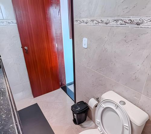 a bathroom with a white toilet and a mirror at Flat - Studio - Casas Arraial Só Lazer in Arraial do Cabo