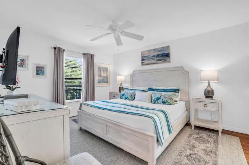 a white bedroom with a bed and a desk at Corner Unit Updated And Near Lobby in Naples