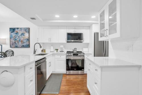 a white kitchen with white cabinets and appliances at Corner Unit Updated And Near Lobby in Naples