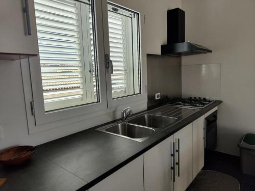 una cucina con un lavandino e una finestra di Brezza di Levante a Calabernardo