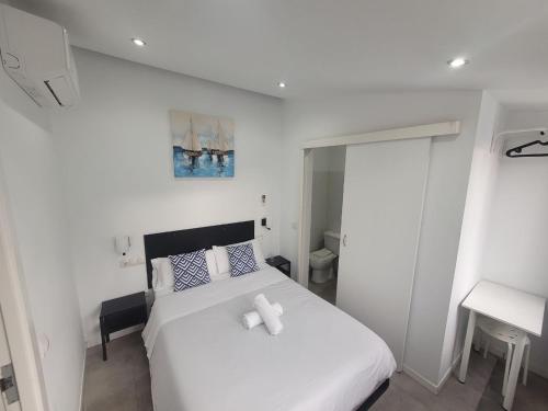 a bedroom with a white bed with two towels on it at AYZ Frailes - Auto check-in property in Málaga