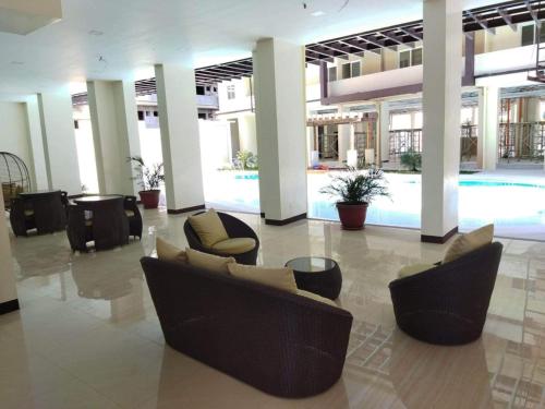 a lobby with chairs and a table in a building at JV Cozy 1 Bedroom Condominium beside SM Mall Marilao in Marilao