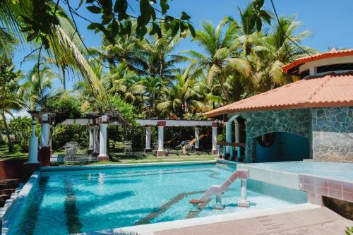 a swimming pool in front of a villa at Las Olas Beach Resort in La Barqueta