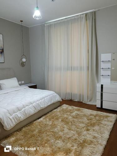 a bedroom with a white bed and a rug at luxury apartment three bedrooms three bathrooms in 6th Of October