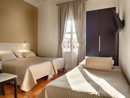 een slaapkamer met twee bedden en een raam bij Sunny Guest House in Rome