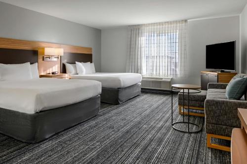 una habitación de hotel con dos camas y un sofá en TownePlace Suites by Marriott Ontario Airport, en Rancho Cucamonga