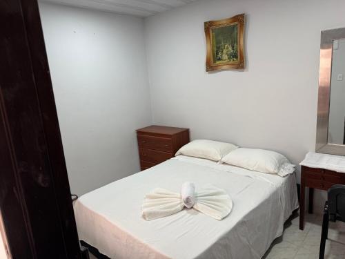 a bedroom with a white bed with a bow on it at Casa hotel la 33 in Medellín