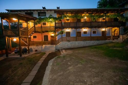 an old house with a courtyard at night at Недкова къща in Koprivshtitsa
