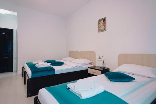 two beds in a hotel room with towels on them at Chalet 173 in Gura Humorului