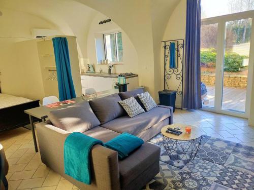 un salon avec un canapé et une cuisine dans l'établissement Magnifiques voûtes avec SPA, à Saint-Amant-Tallende