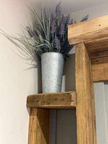 a vase of purple flowers sitting on a wooden shelf at Orchard Retreat Staycation in Boston