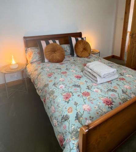 a bed with two pillows on top of it at Wheel Corner Cottage in Kingsteignton