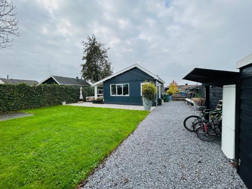 a house with a green yard with bikes parked in front at Nice chalet near Reeuwijkse plassen in Reeuwijk