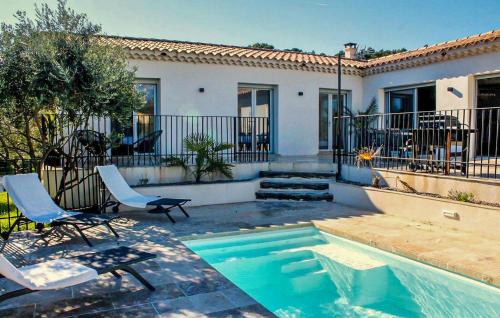 a swimming pool with two chairs and a house at 3 Bedroom Cozy Home In Mormoiron in Mormoiron