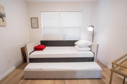 a small room with two beds and a window at Big Family House w Theater Pool table in San Antonio