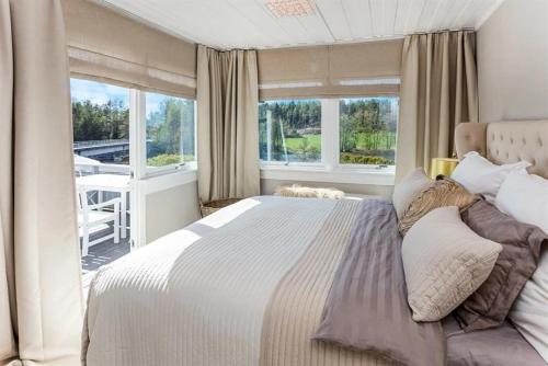 a bedroom with a large bed and a balcony at Beachfront cottage with sea view in Dillingøy