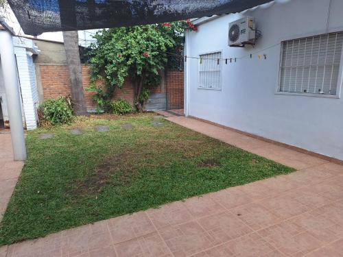 an empty yard with a white wall and a building at Cálida y Familiar in Salto