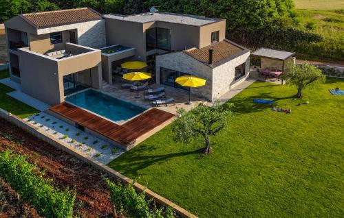 an aerial view of a house with a pool and umbrellas at Stunning Home In Kastelir With Sauna in Kaštelir