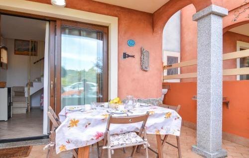 1 Bedroom Lovely Home In Viddalba في Viddalba: طاولة طعام مع طاولة بيضاء من قماش وكراسي