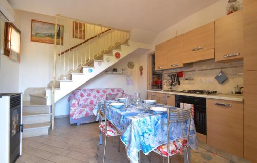 1 Bedroom Lovely Home In Viddalba في Viddalba: مطبخ مع طاولة مع كراسي ودرج